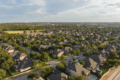 Bird’s-eye view of a picturesque neighborhood in Cedar Park, Texas, featuring tree-lined streets, beautiful homes, and a tranquil suburban setting.