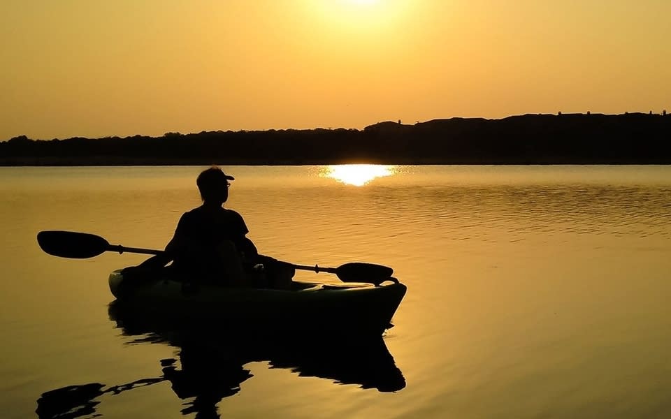 Enjoy your Cedar Park Summer vacation with a scenic sunset view from a paddle boat on Twin Lakes Park, Cedar Park, Texas.