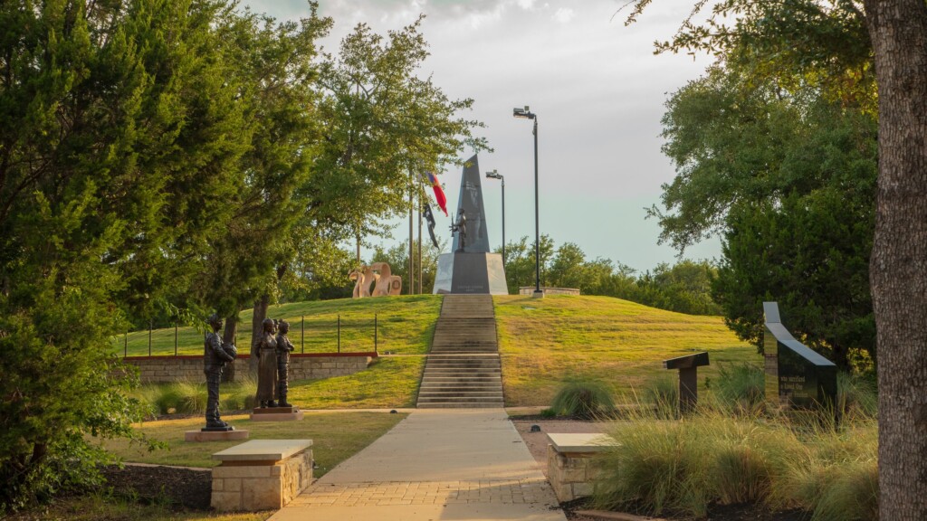 A tranquil scene at Veterans Memorial Park in Cedar Park, Texas, showcasing lush greenery, walking paths, and a peaceful atmosphere.