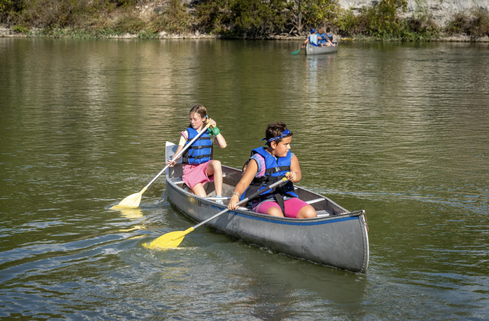 Paddle boats on a lake in Cedar Park, Texas, with people enjoying a summer activity.