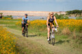 People biking along a scenic trail surrounded by greenery at Brushy Creek Lake Park in Cedar Park Texas during summer