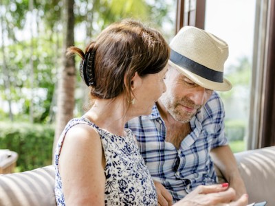 a man and woman sitting on a couch looking at something